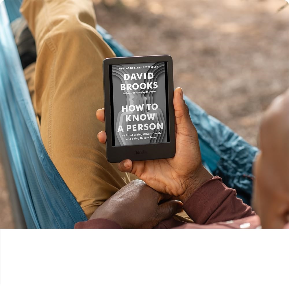 a man reading a book on a kindle in a hammock